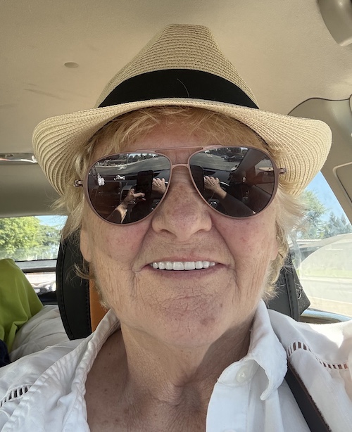 Woman in hat in car with sunglasses