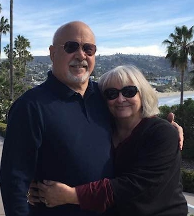 Charlie and Nancy Bednar in sunglasses with palm trees and mountains