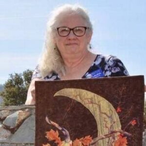Woman holding art quilt outside