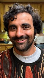 Santiago Palacio in a sweater smiling at the camera